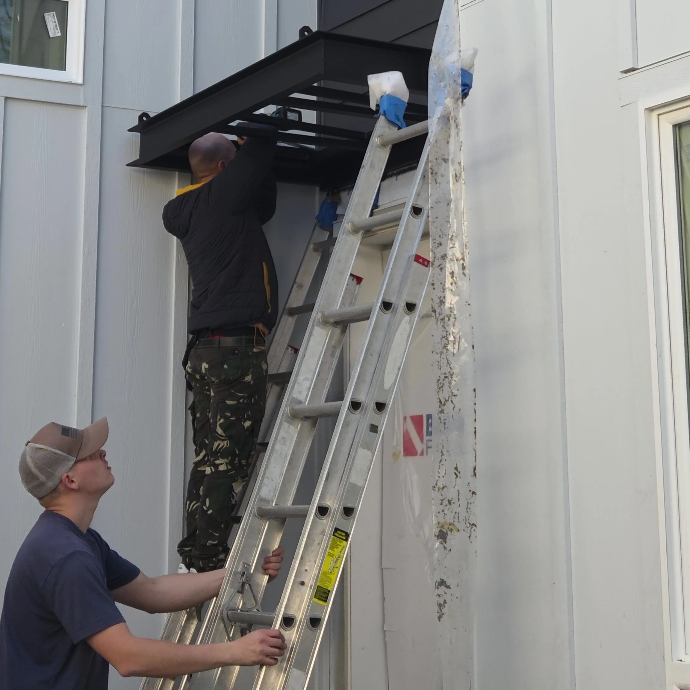 Brothers Metal team installing a custom metal awning